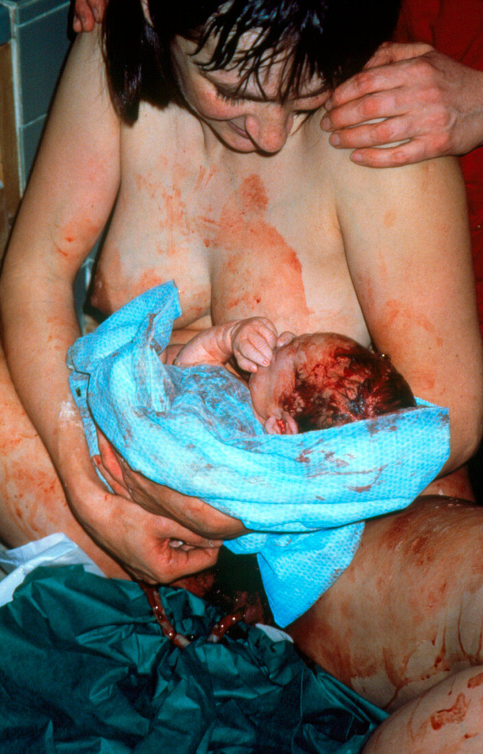 Natural childbirth: mother holding newborn baby