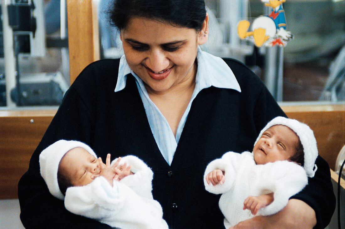 Mother holding newborn twins