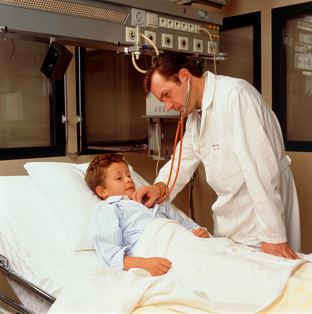 Doctor uses a stethoscope on a boy in hospital