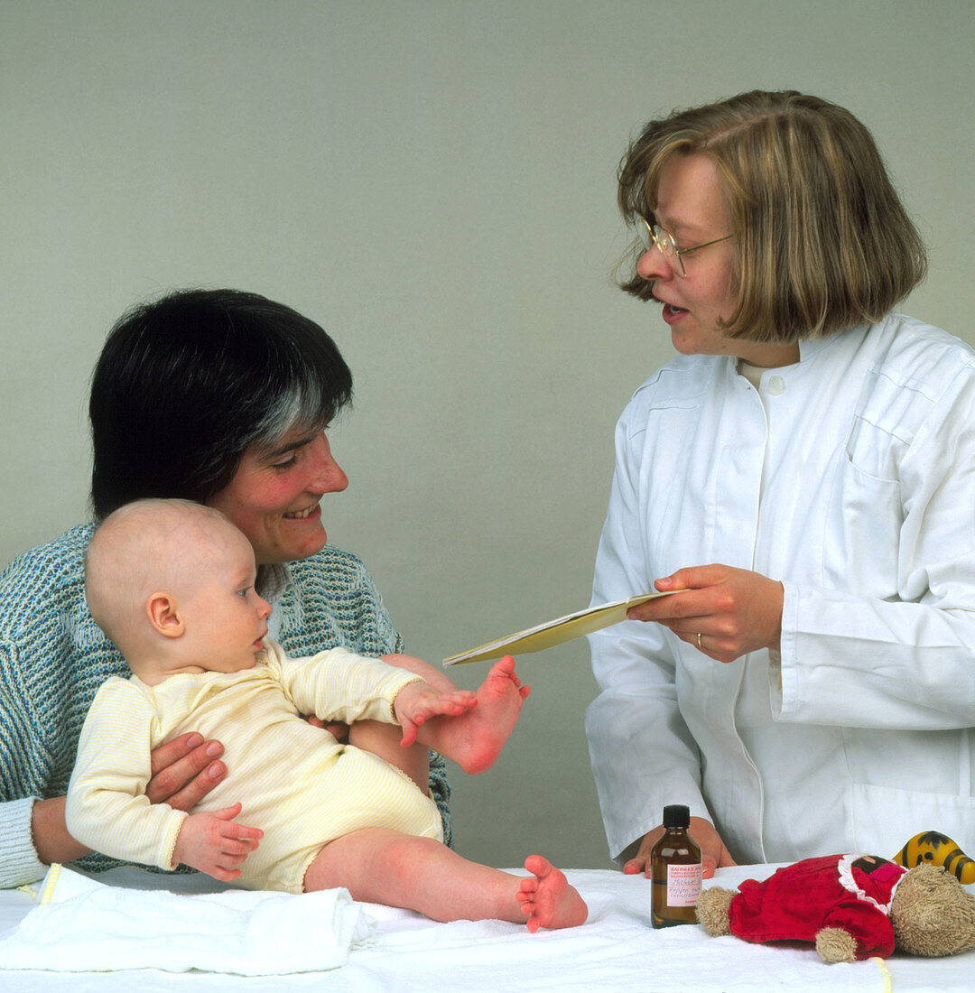 A mother and baby attend a paediatric examination