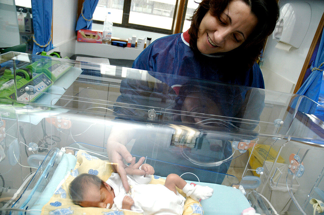 Mother stroking her premature baby