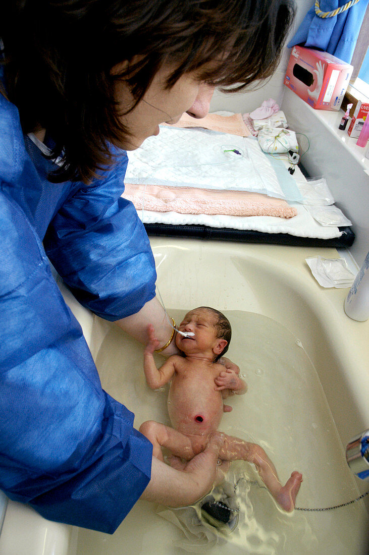 Mother washing her premature baby