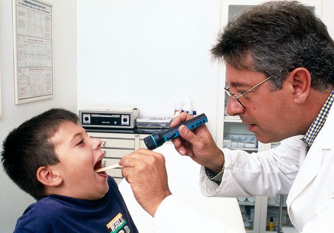 Young boy having a throat examination