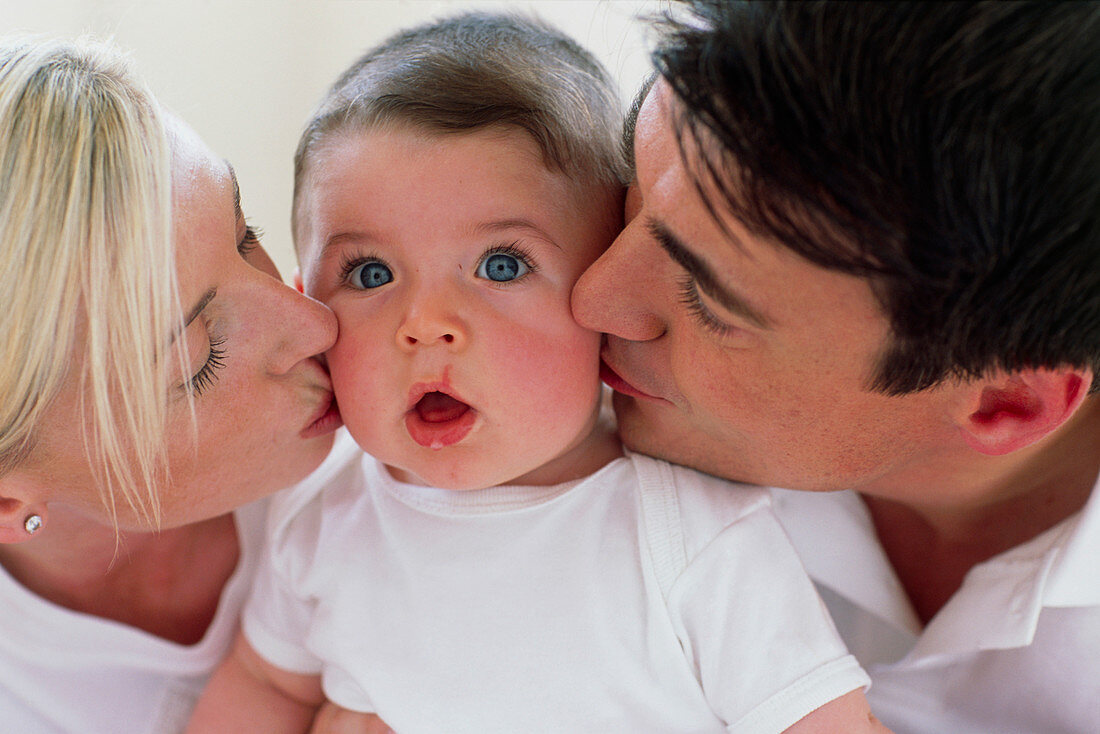 Parents kissing baby boy