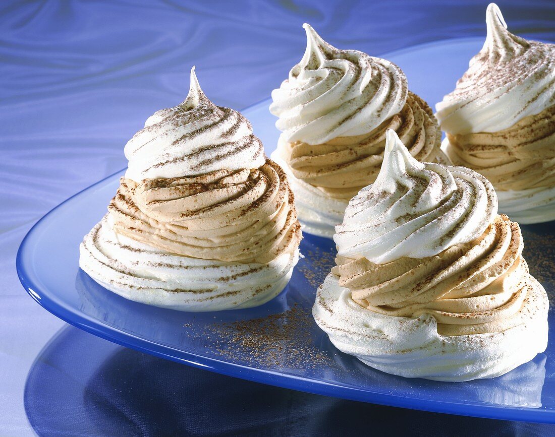 Meringues filled with mocha cream on glass plate