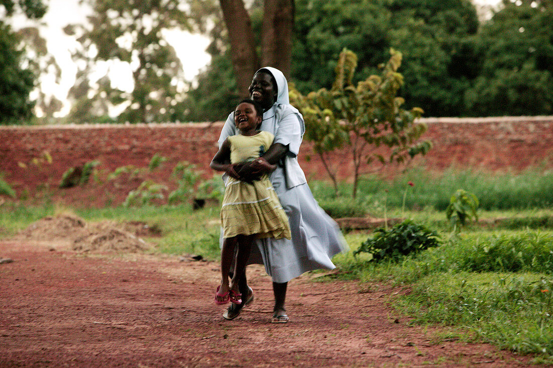 Ugandan nun holding orphaned child
