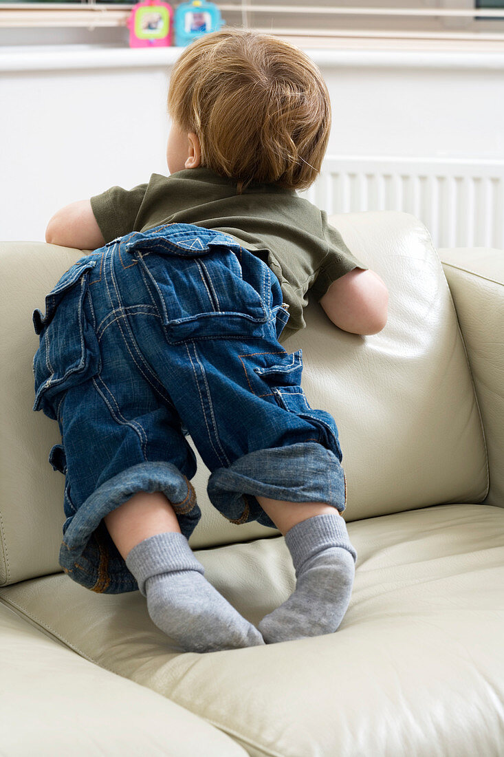 Toddler climbing on a sofa