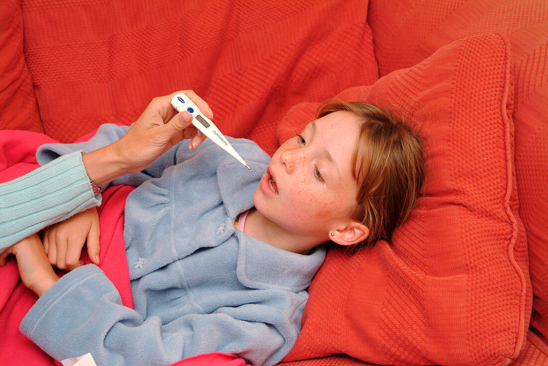 Unwell girl having her temperature taken