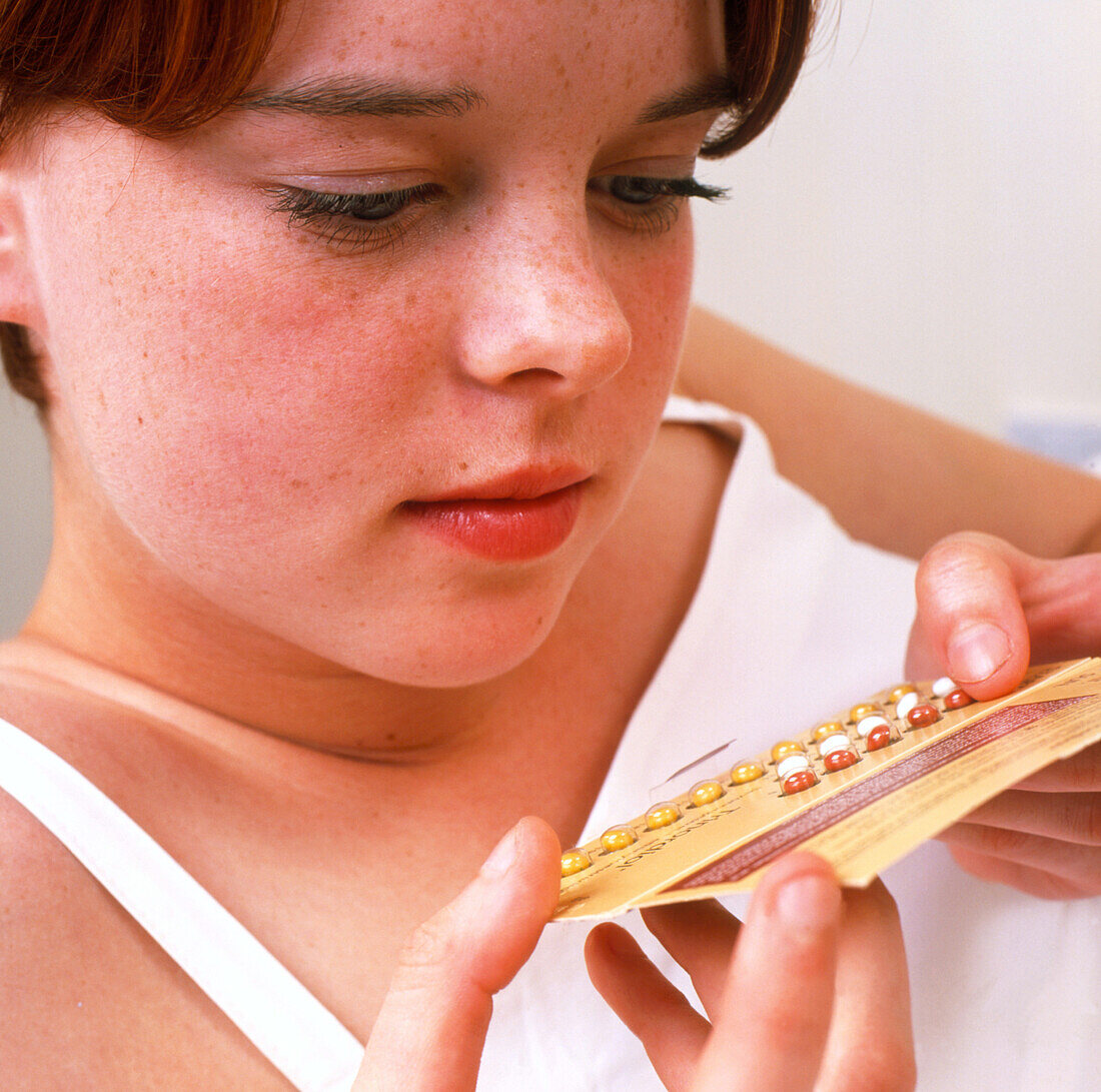 Teenage girl holding pack of contraceptive pills