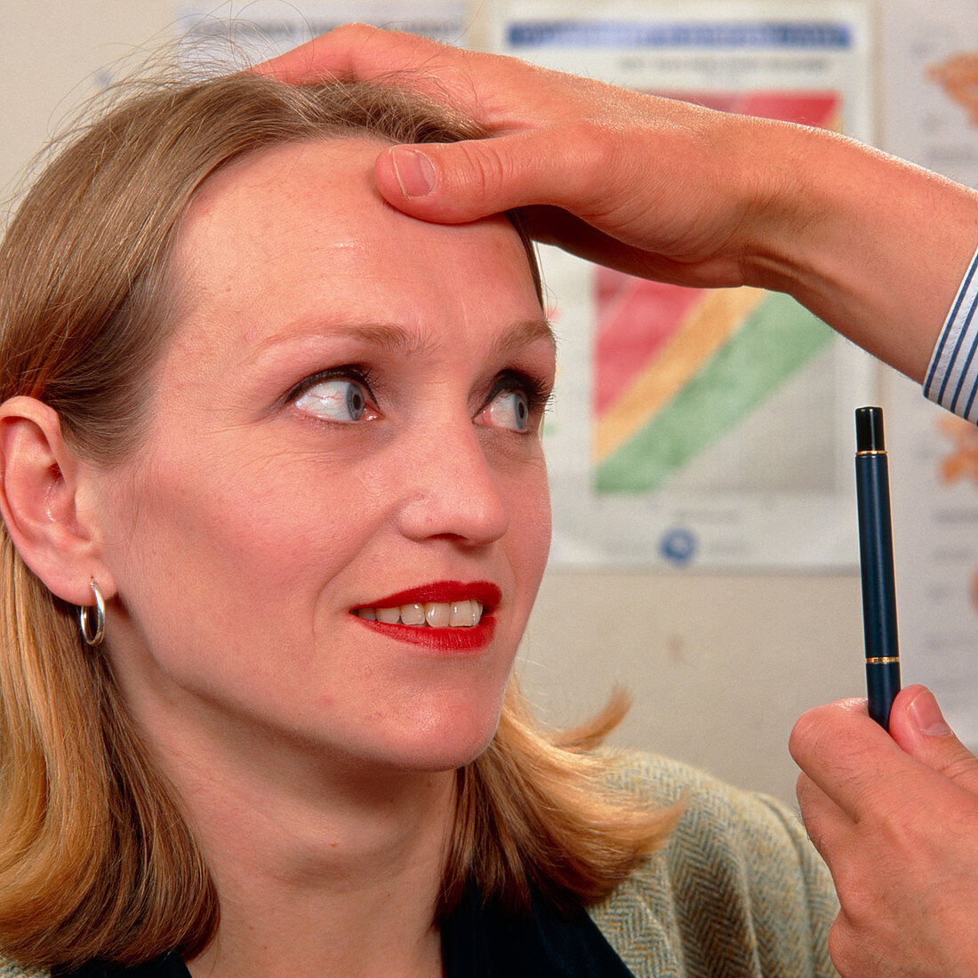 GP doctor examines the eyes of a woman
