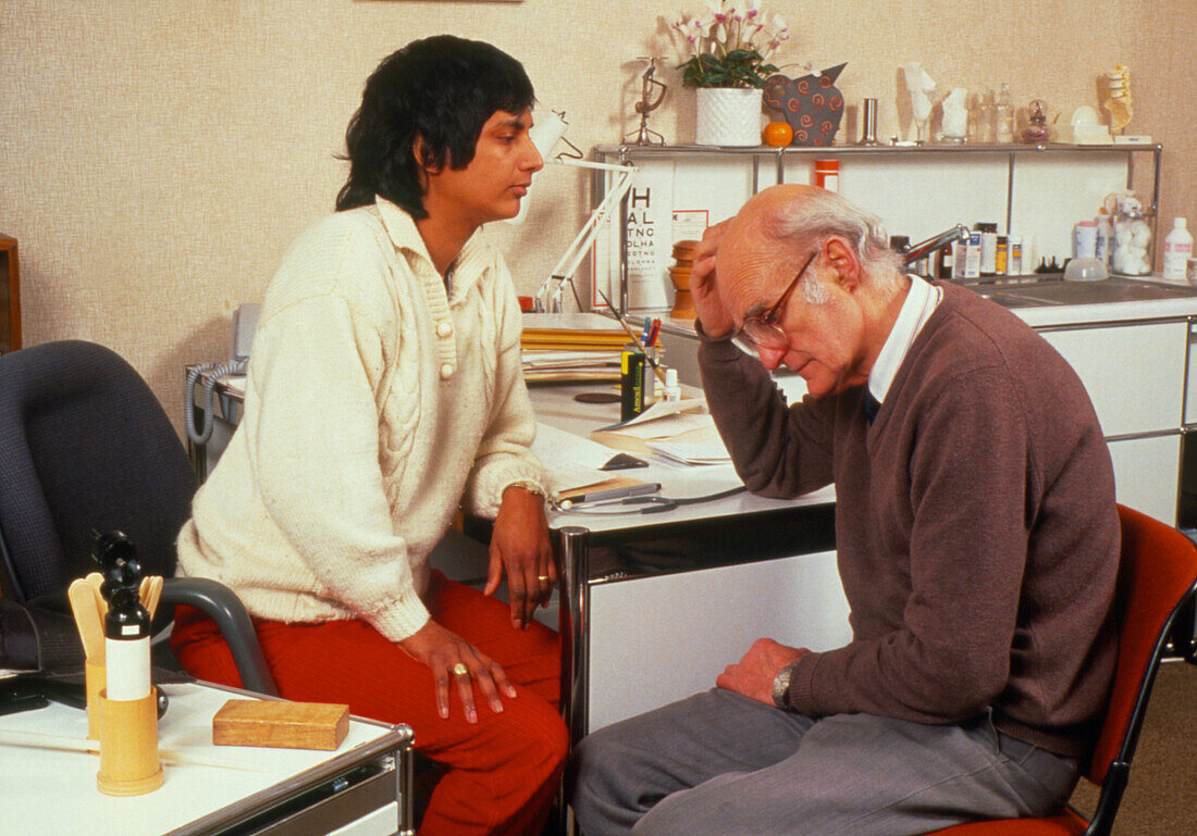 Doctor examining the scalp of a bald man