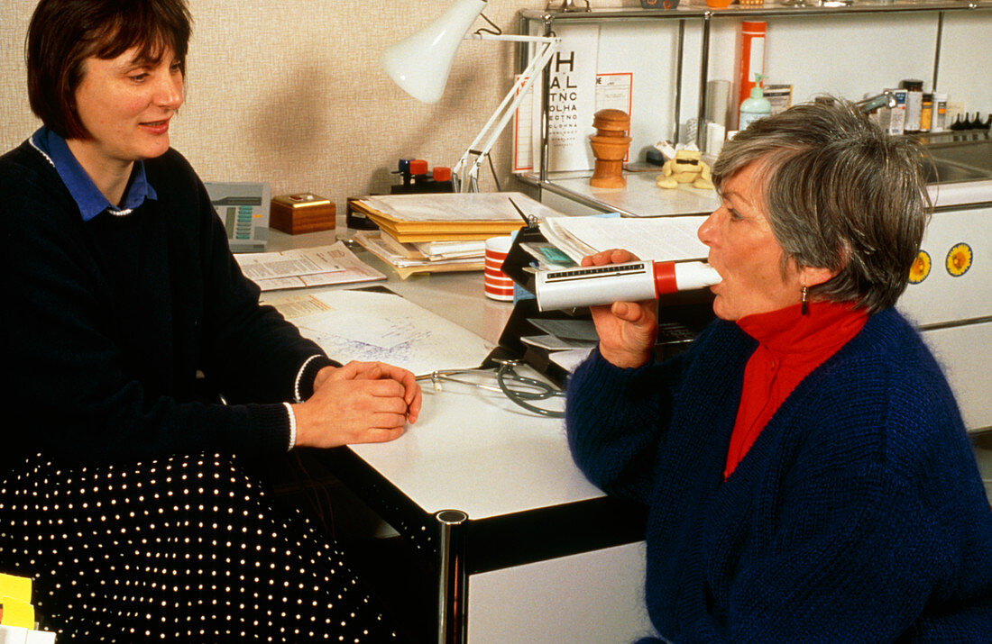 Doctor tests elderly patient with peak-flow meter