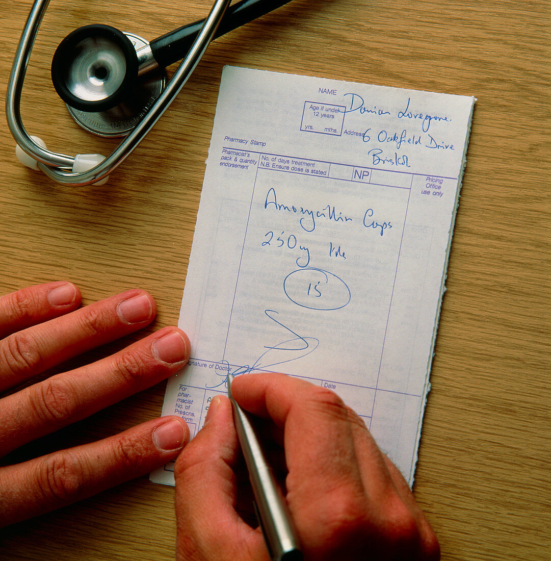 Doctor signing a prescription for amoxycillin
