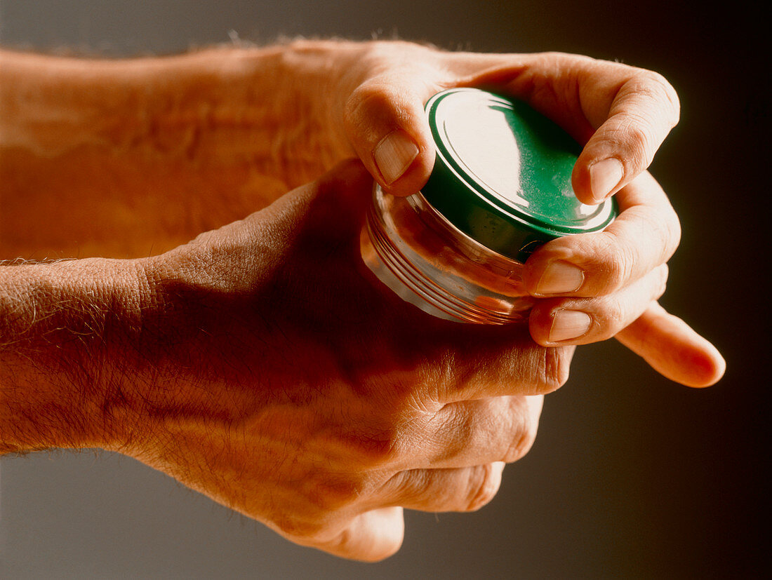 Man's hands clasping a jar