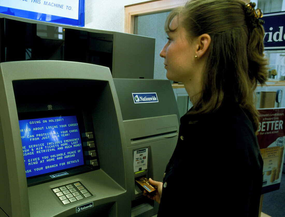 Woman has eye iris scanned at a bank cash machine