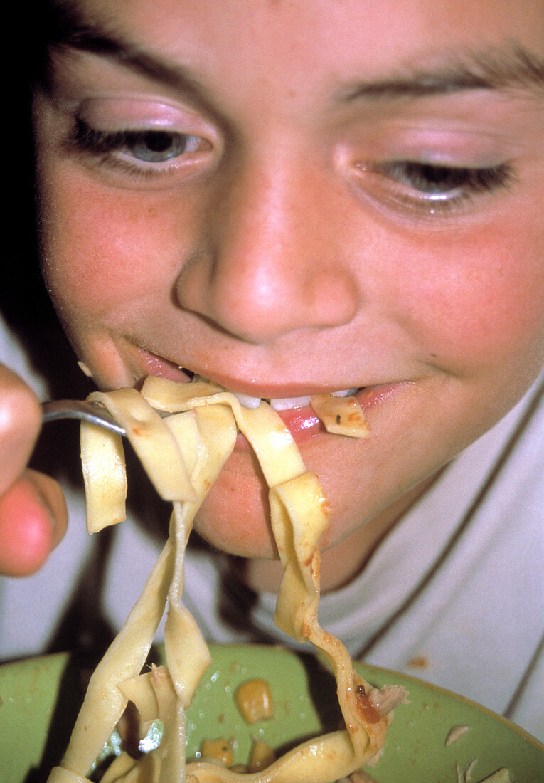 Hungry boy eating pasta