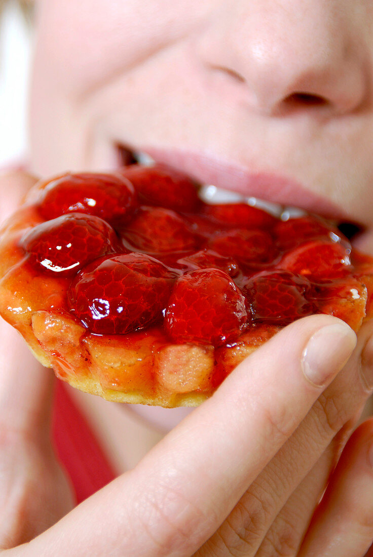 Woman eating a strawberry tart