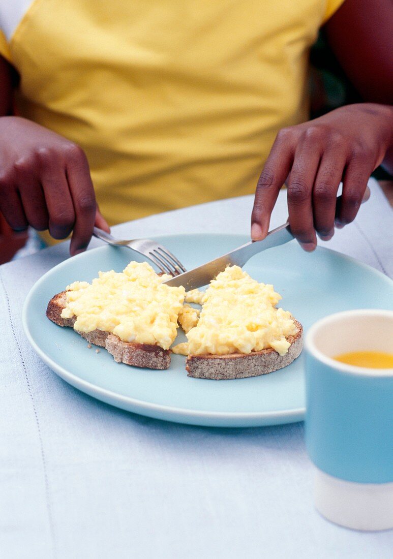 Eating scrambled eggs on toast