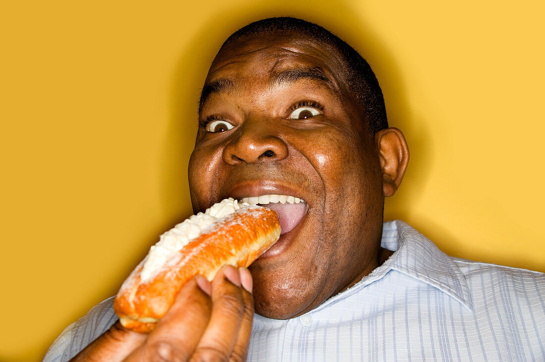 Man eating a creamy finger doughnut