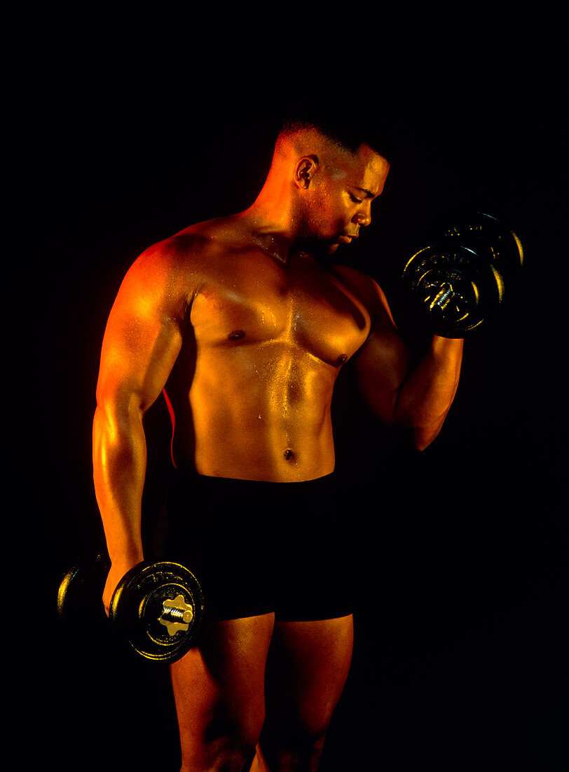 Bodybuilding: man using dumb-bell on his biceps