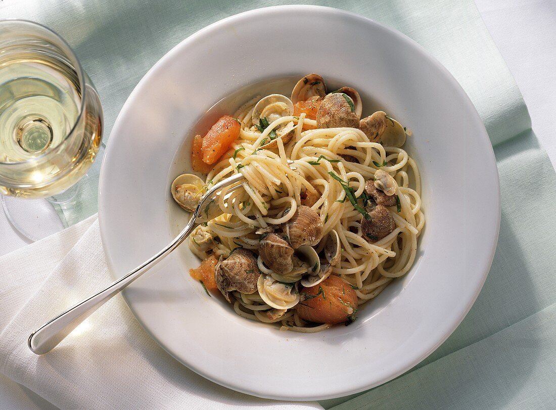 Spaghetti with clams & tomato slices on plate