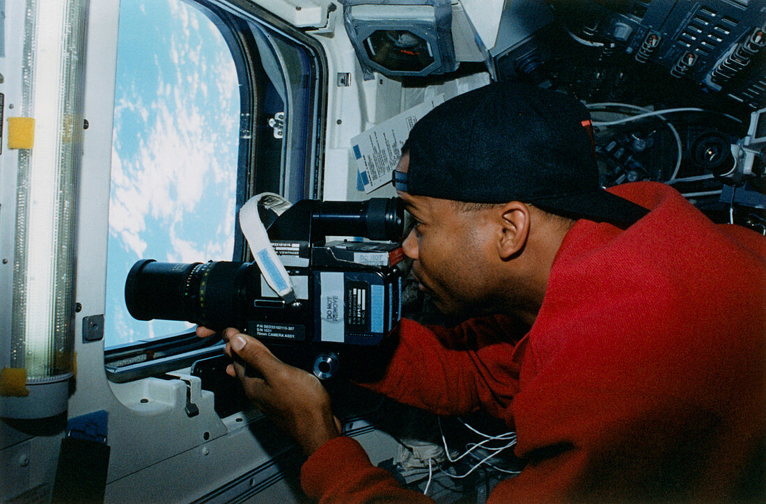 Astronaut uses a video camera on the space shuttle