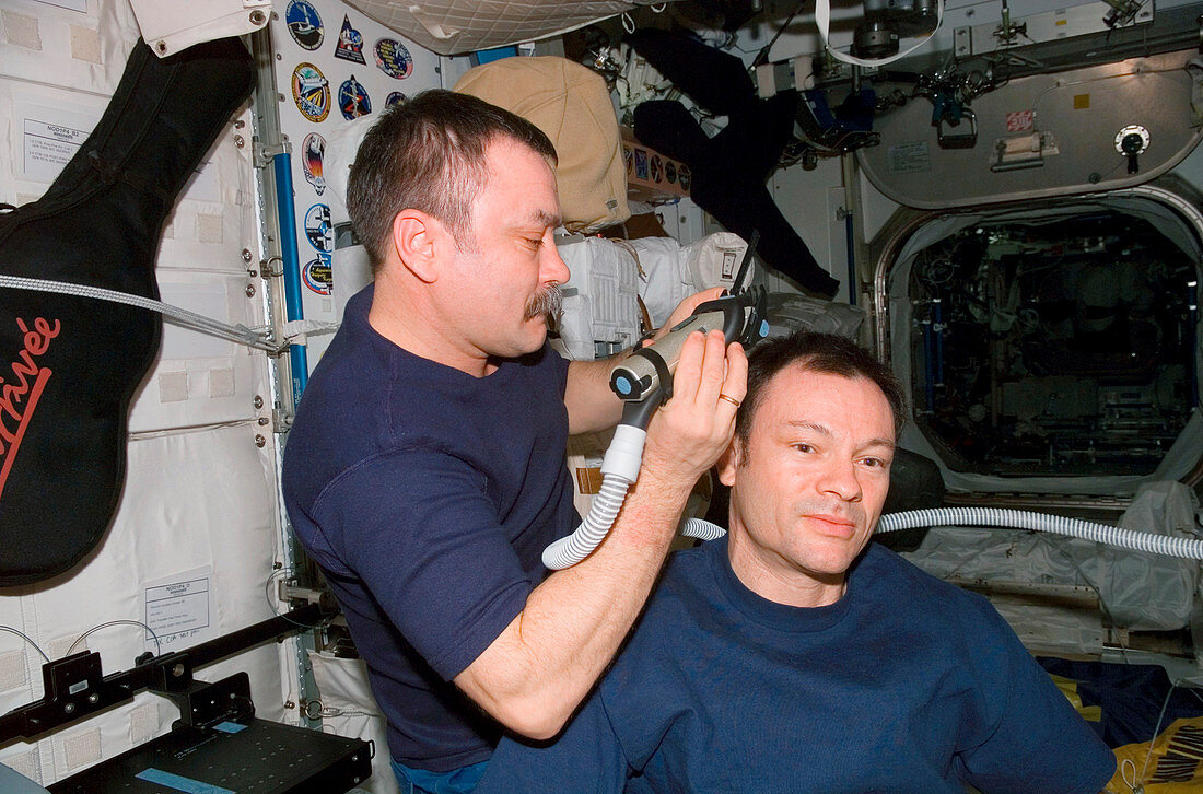 Astronaut having his hair cut in space