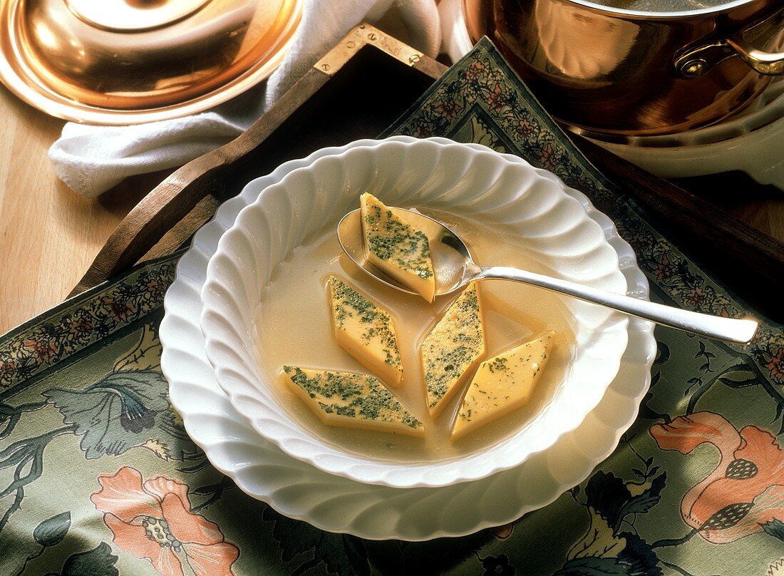 Clear broth with herb egg custard on plate