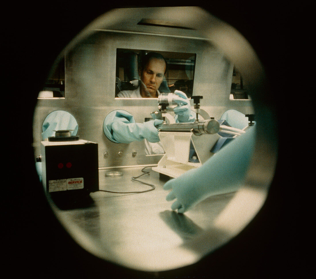 Worker handling plutonium in a glove box