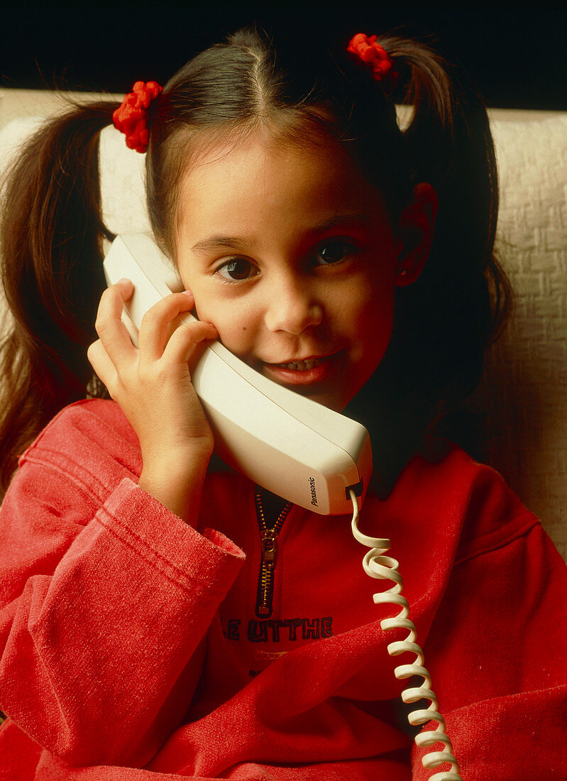 Young girl talks on a telephone