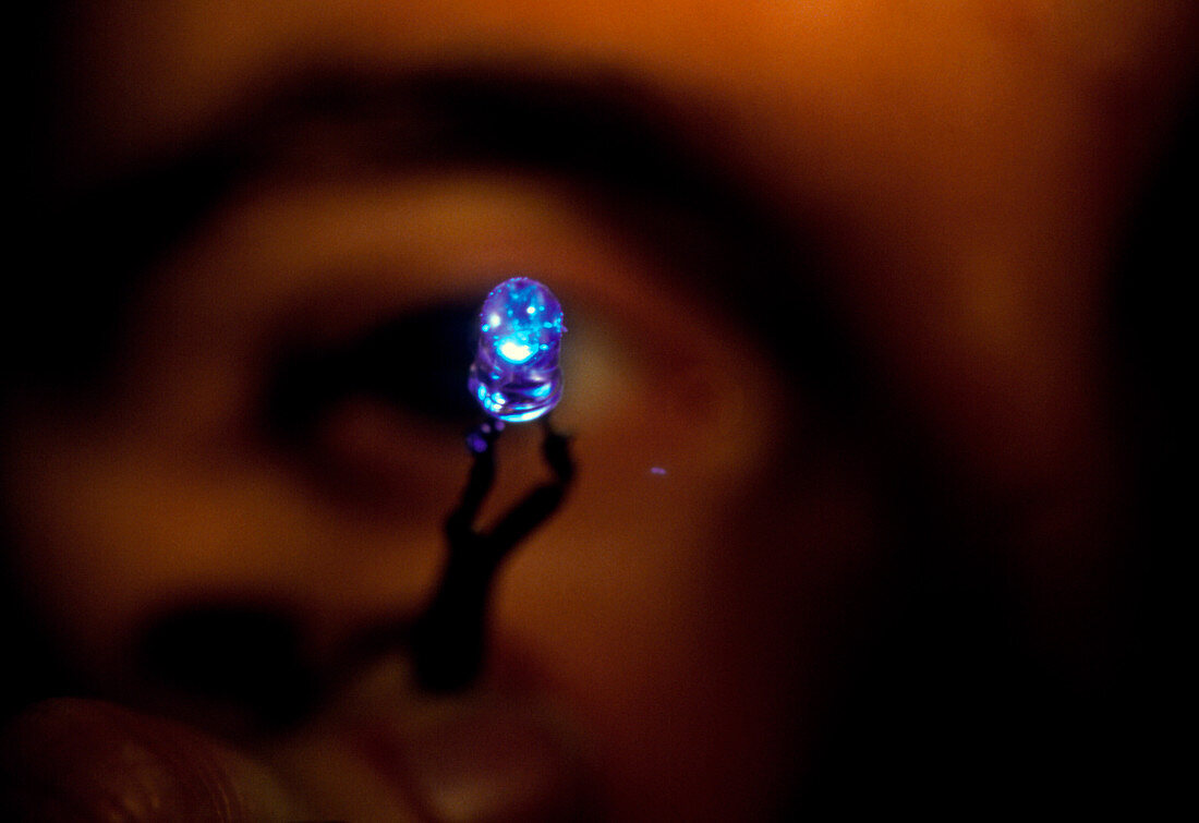 View of a man holding a blue light emitting diode
