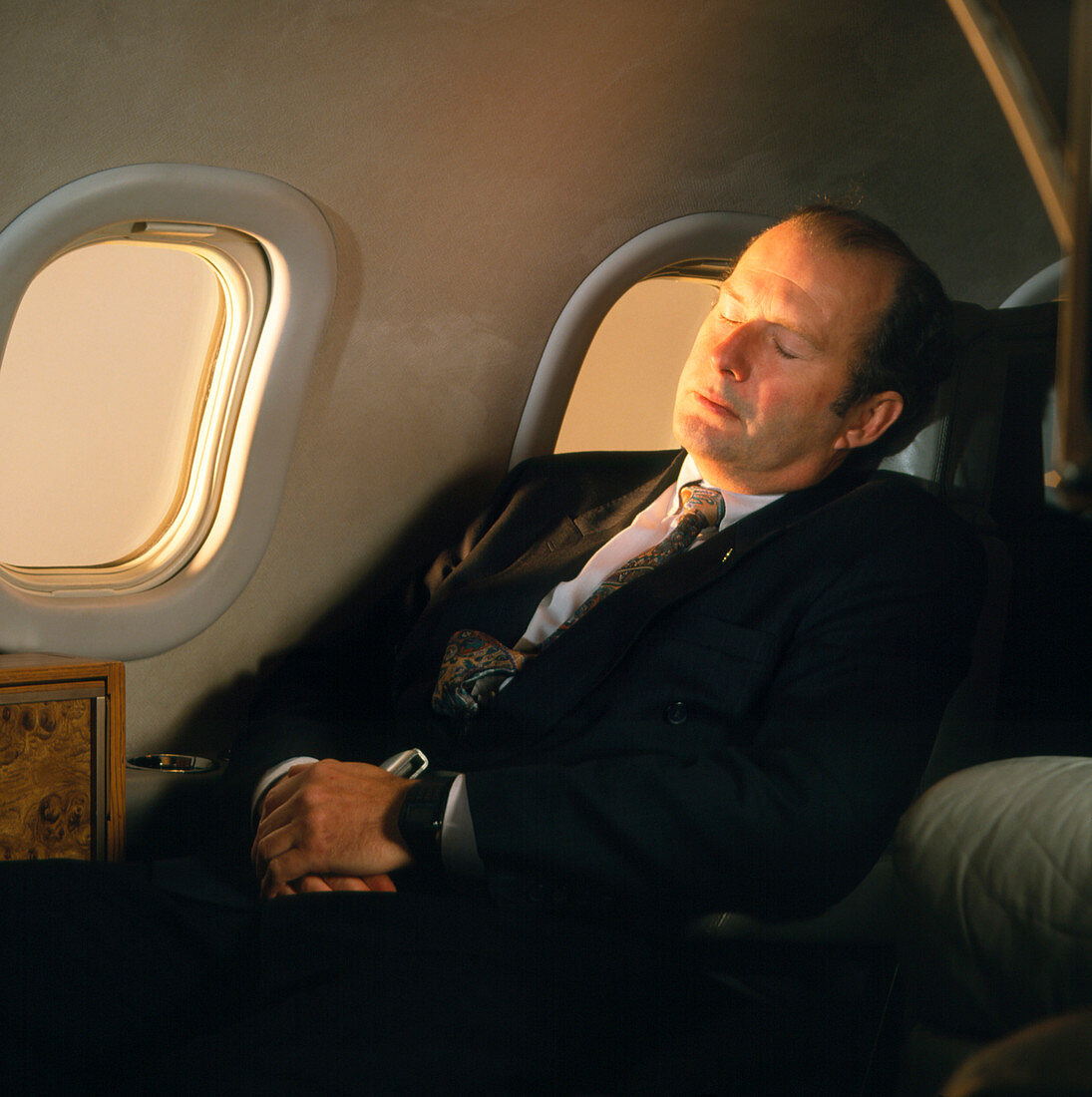 Businessman sleeps while travelling by aeroplane