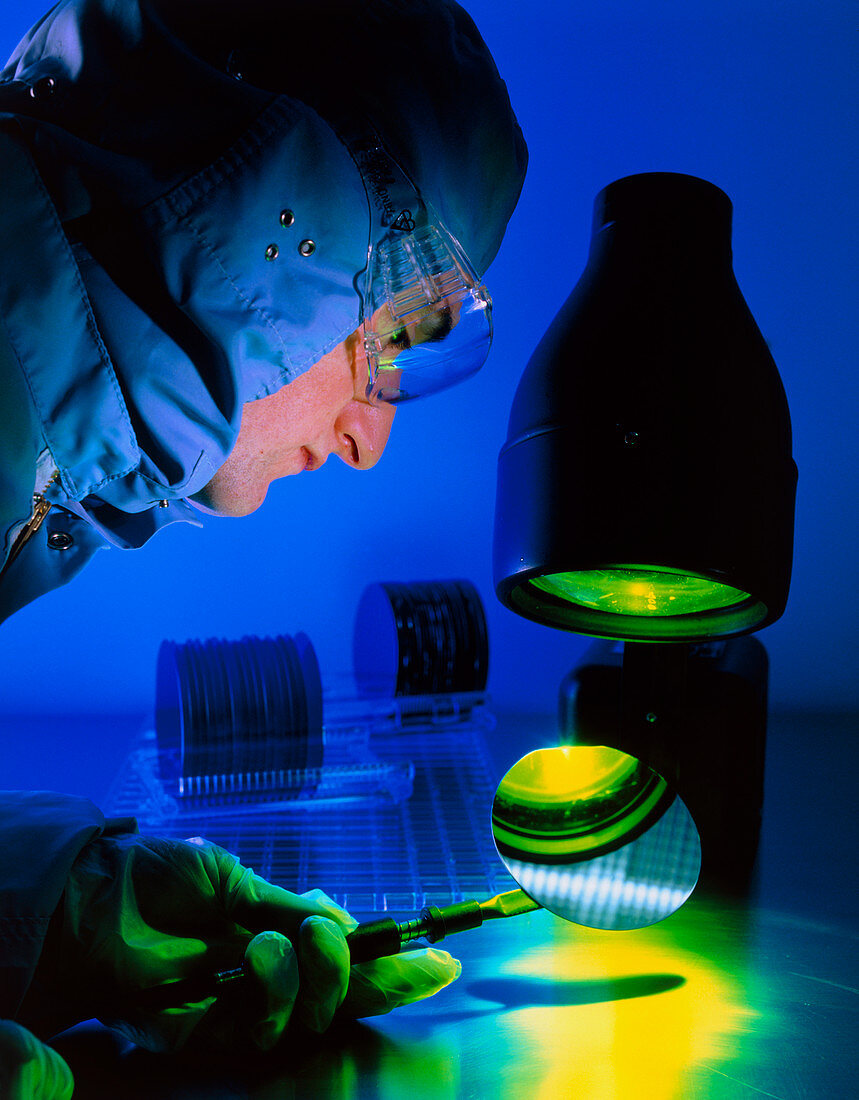 Technician inspecting silicon wafers