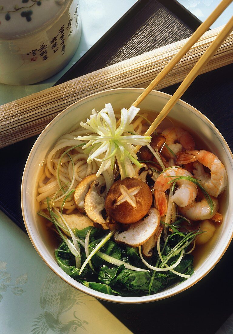 Noodle stew with shrimps, shiitake and spinach in bowl