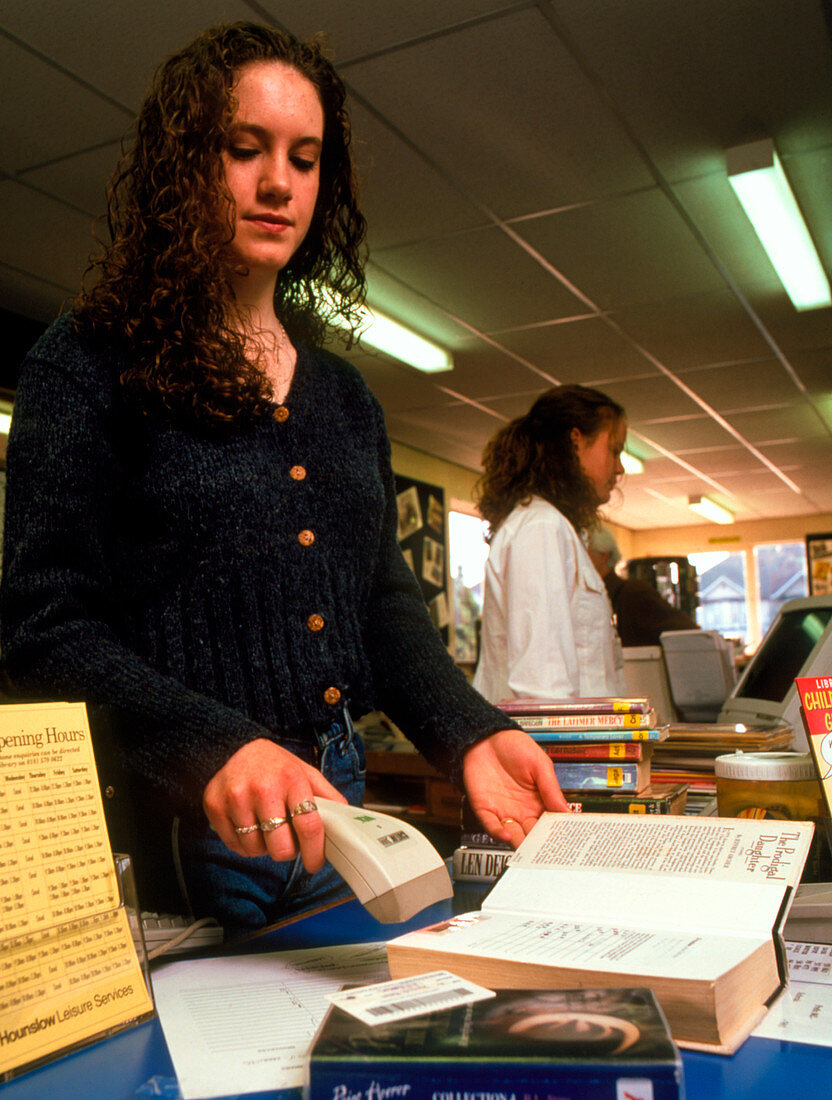 Woman using a bar code scanner in a library