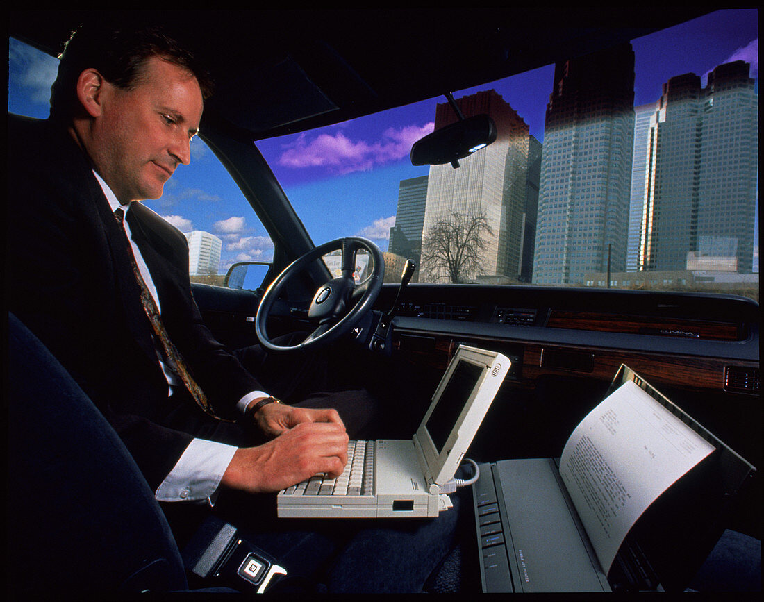 Businessman with laptop computer & printer in car