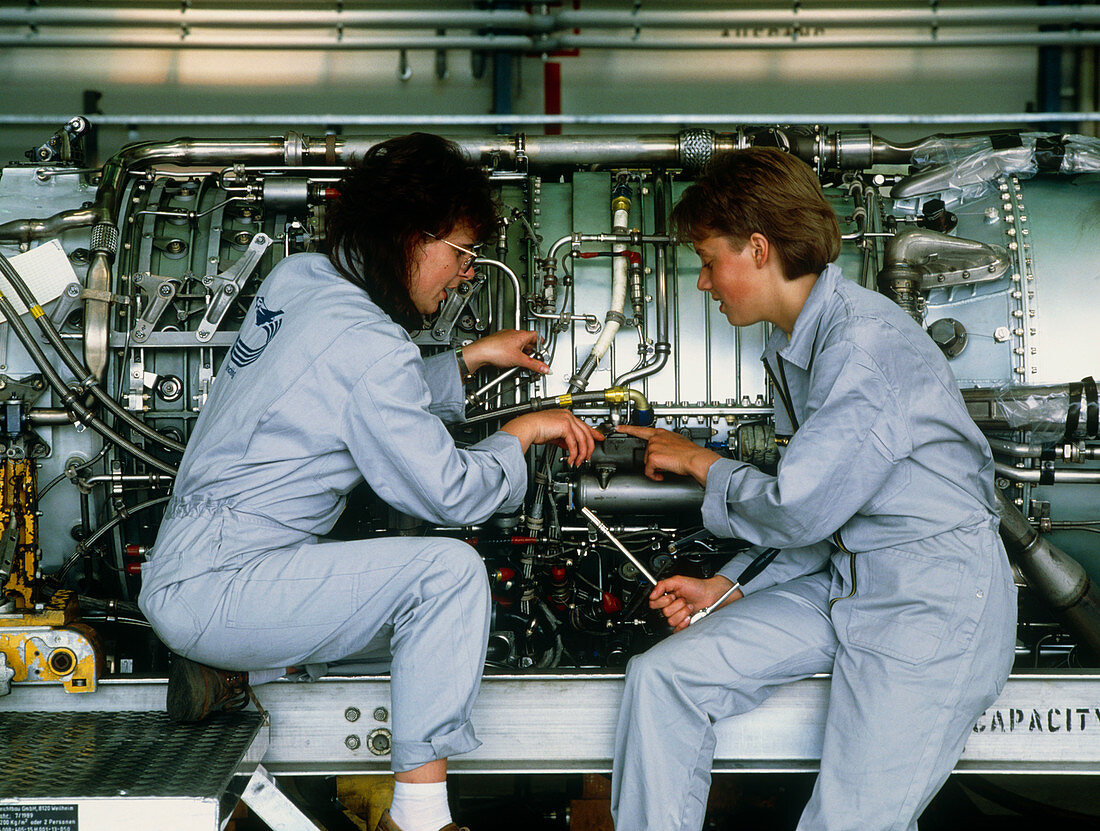 Female engineers assembling an aircraft jet engine