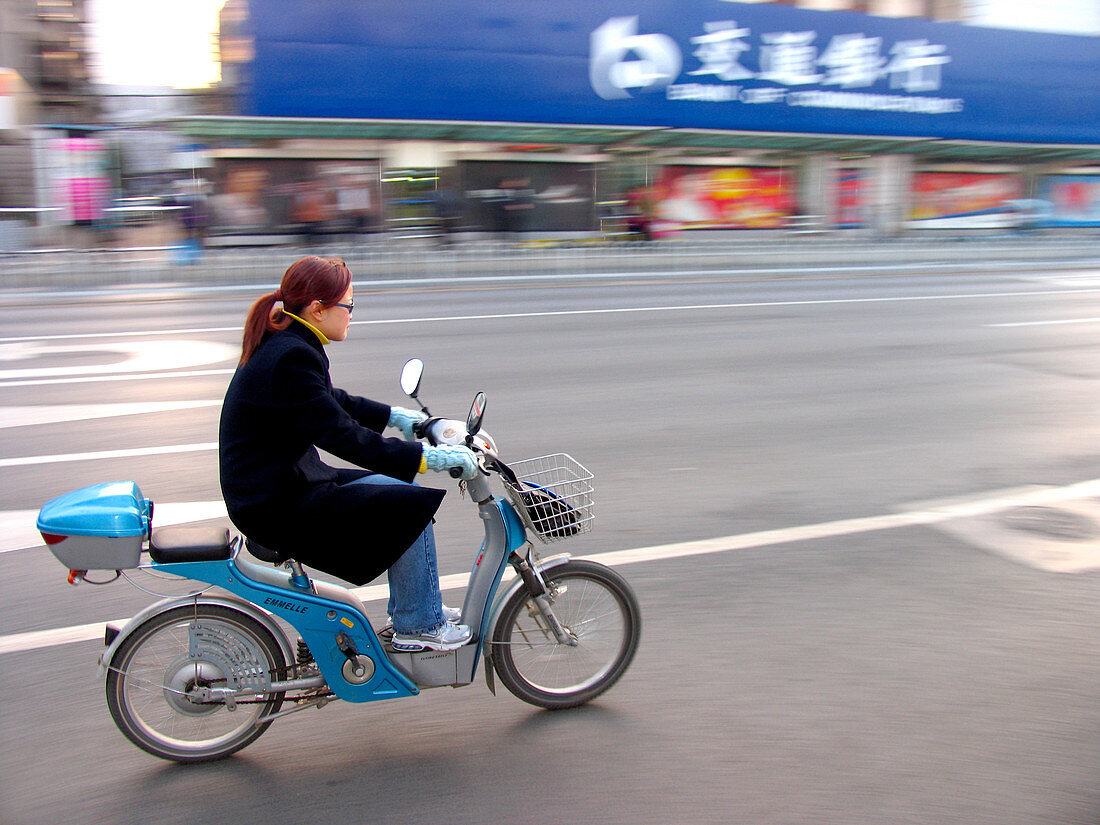 Woman on an electric moped