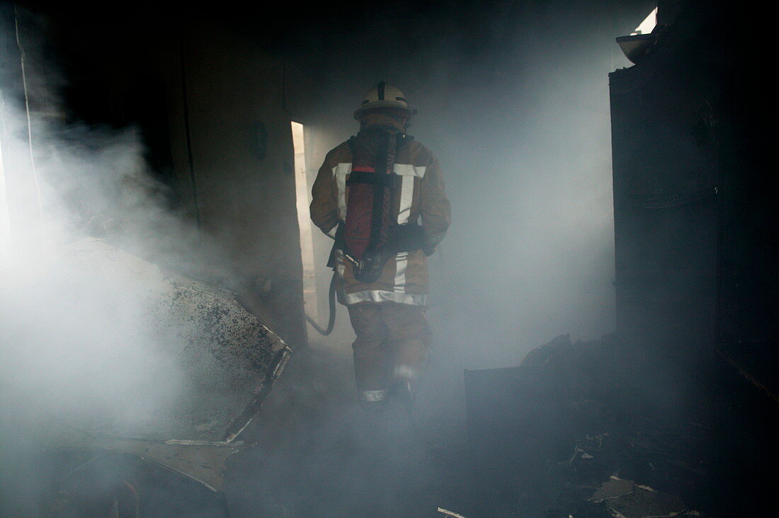 Fire fighter in a burnt house