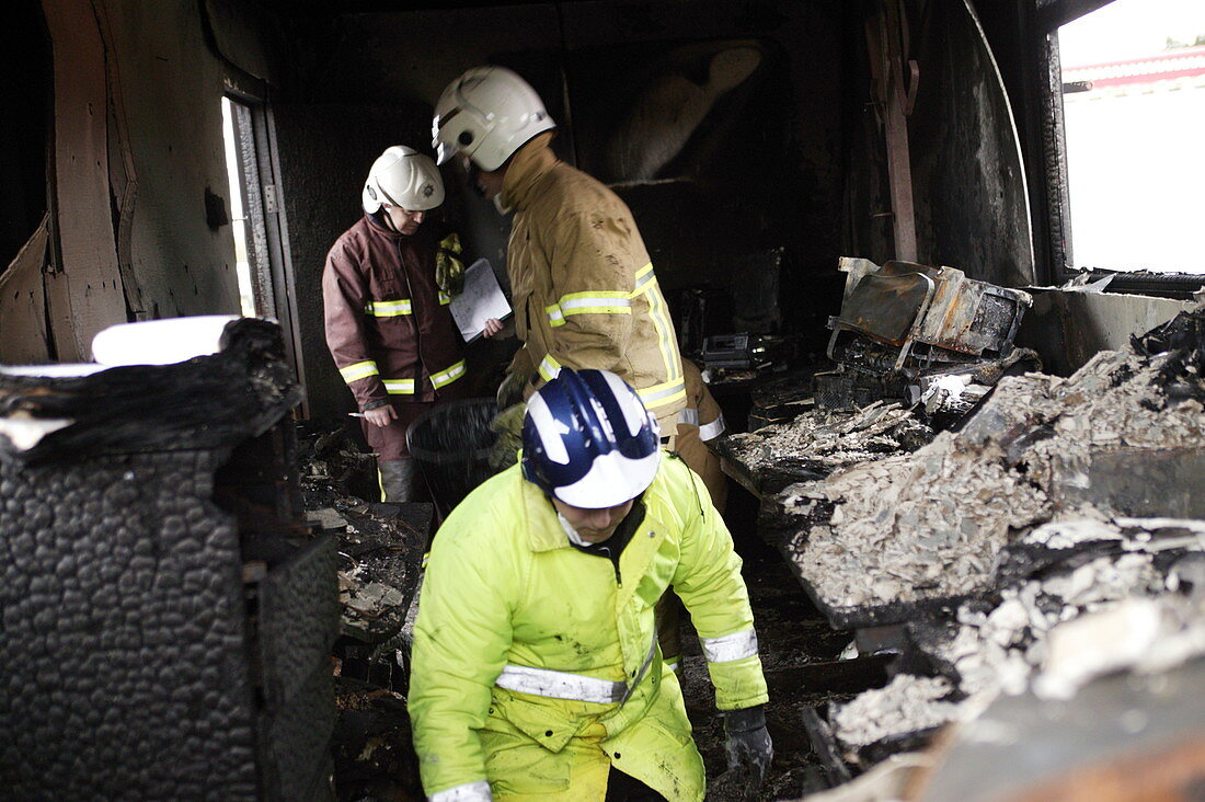 Firefighters in a burnt-out house