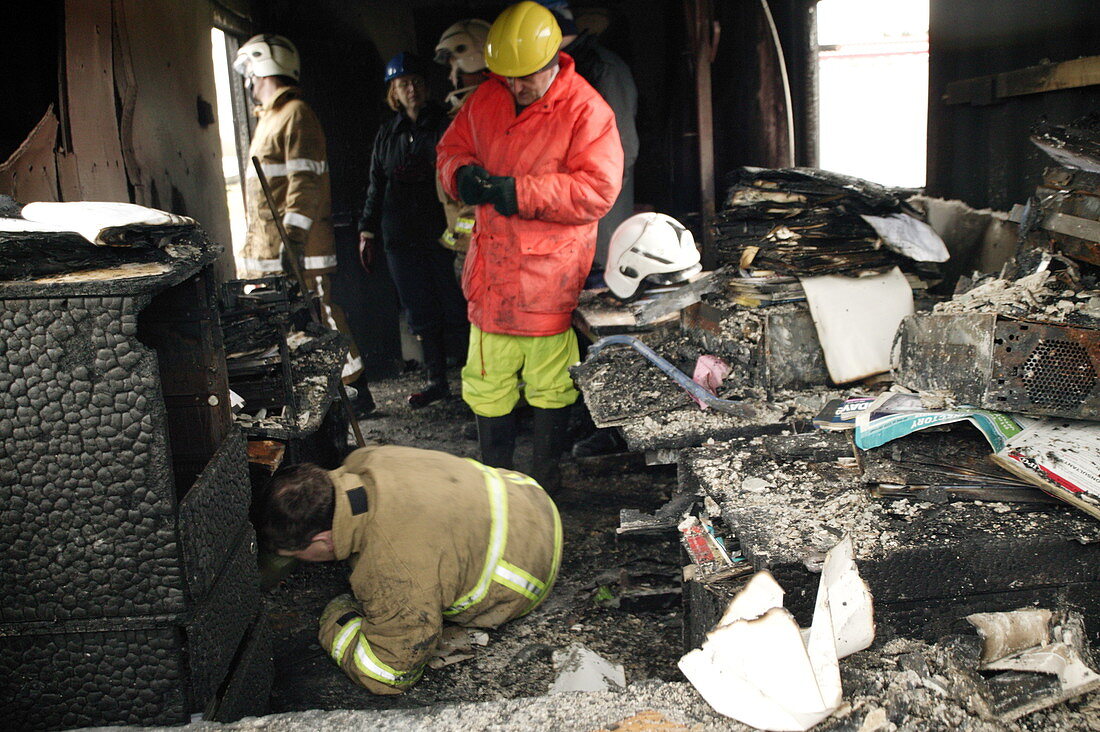 Firefighters in a burnt-out house