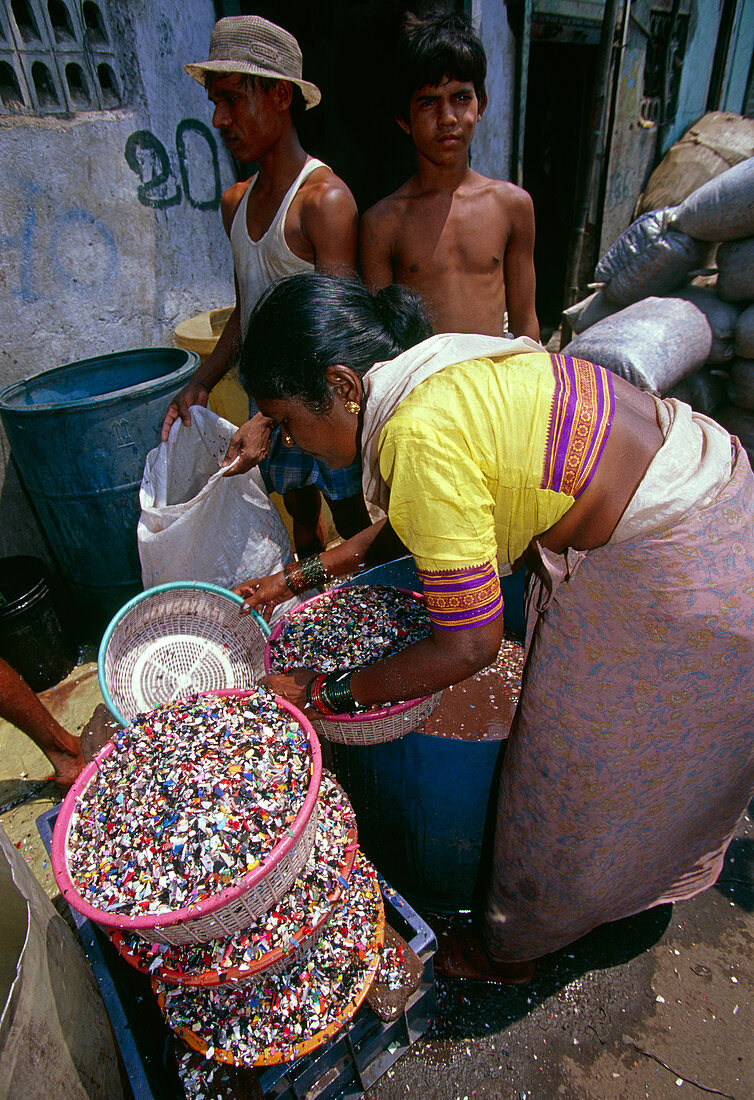 Woman sorting plastic waste to separate out PVC