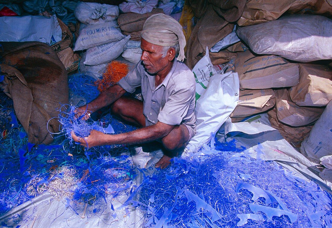 Man sorting plastic waste to separate out PVC