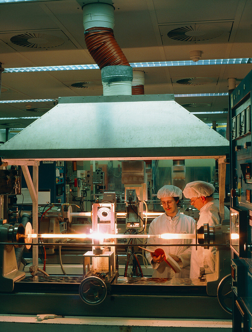 Workers making a glass blank for an optical fibre