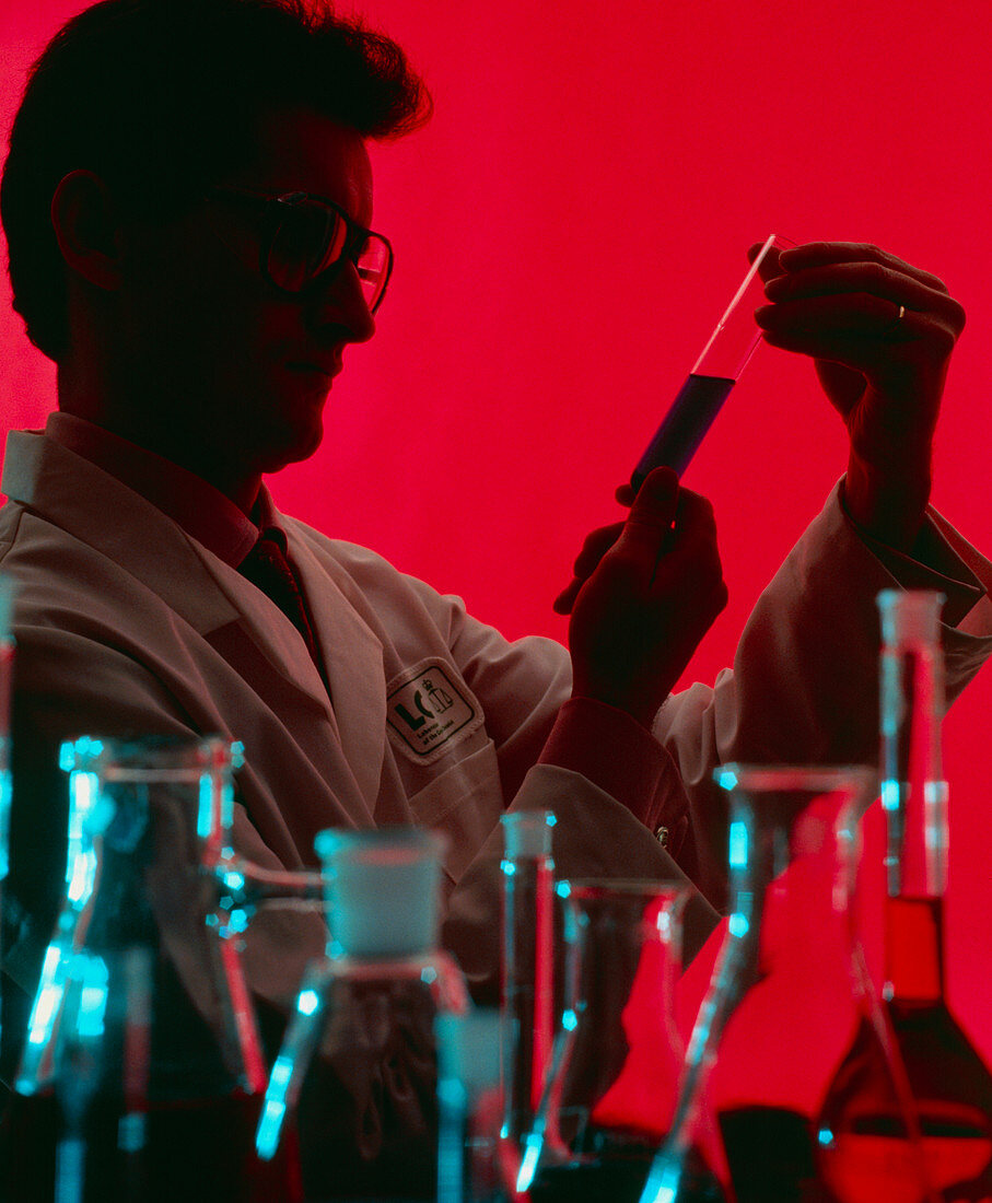 Technician looking at the contents of a test tube