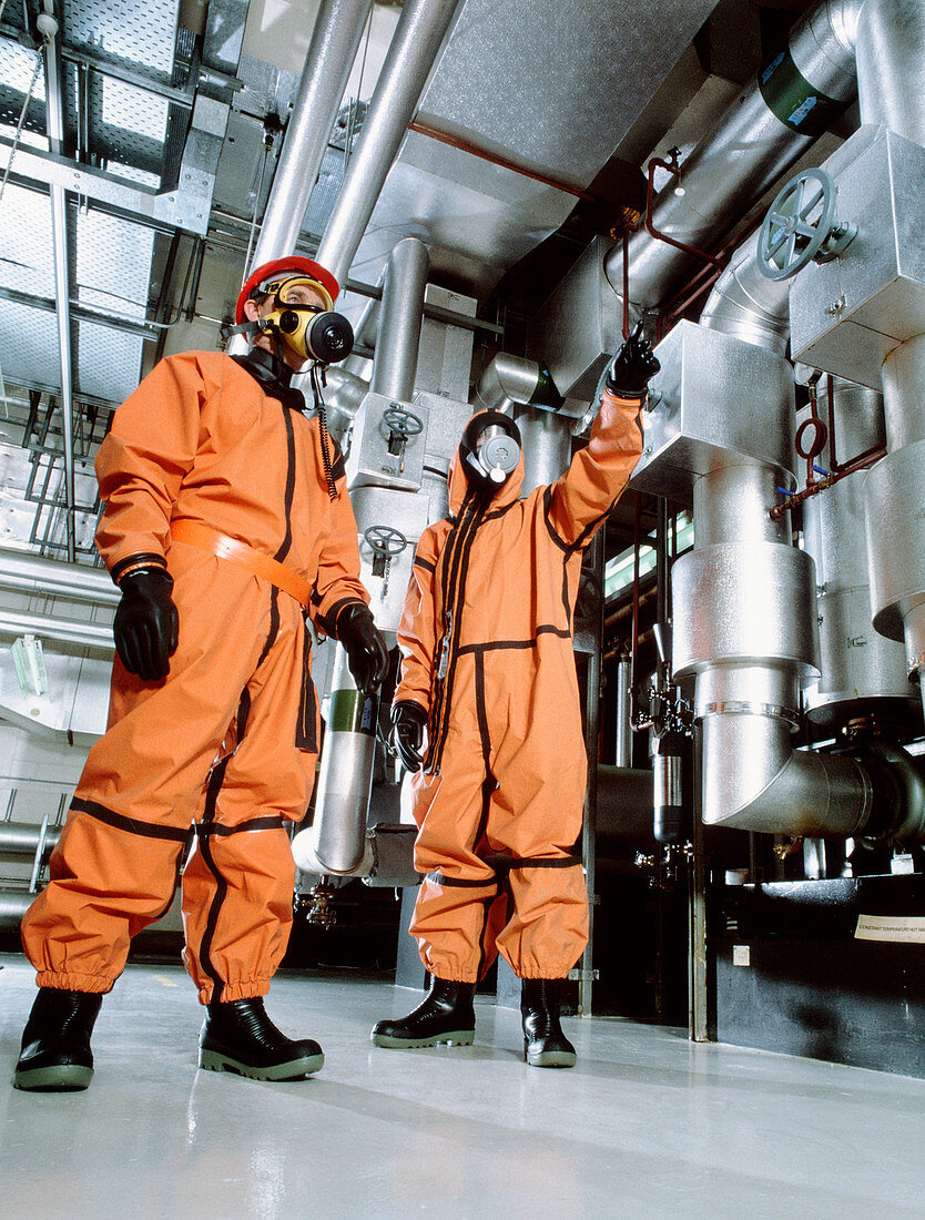 Workers in a factory wearing chemical suits
