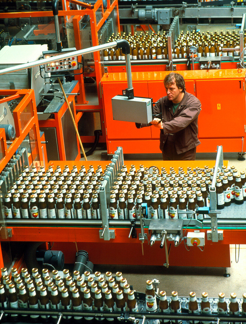 Worker on a fruit juice bottling production line