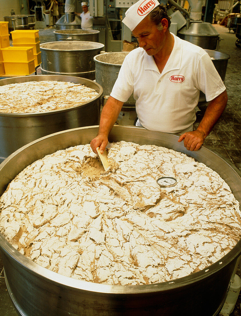 Baker beside a vat of sour dough