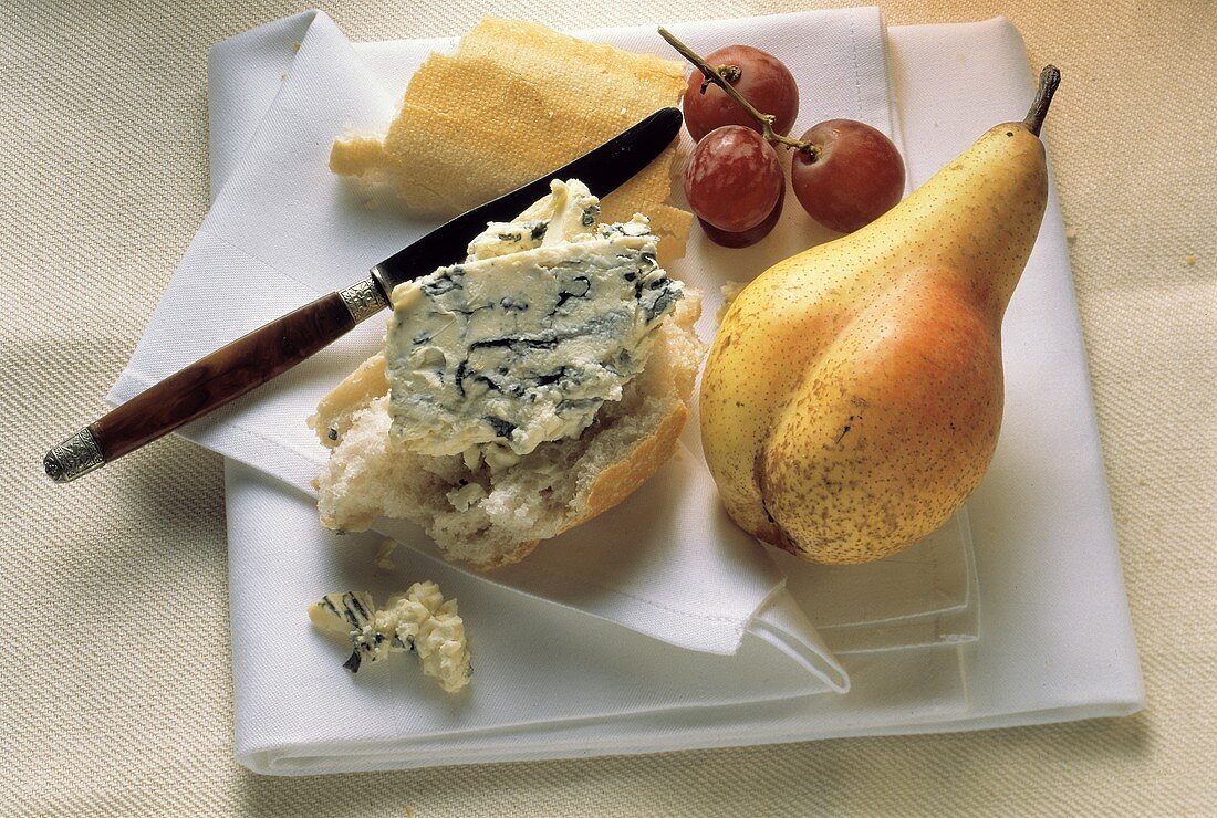 Stillleben mit Käse (Saint Agur) auf Baguette, Birne & Trauben