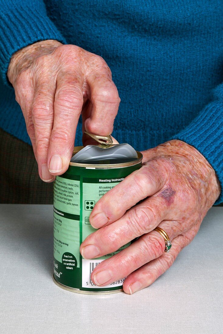 Elderly woman opening a tin